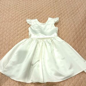Beautiful ivory flower girl dress with bow and beading back detail.
